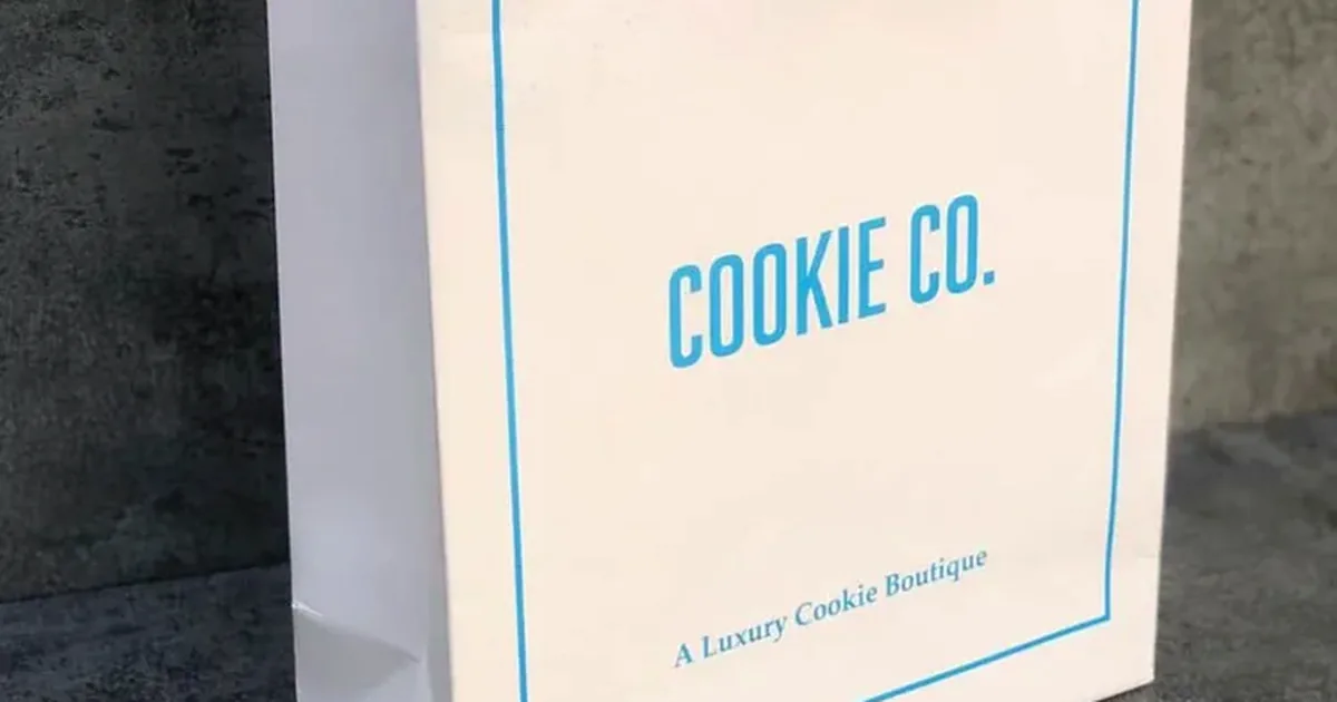White Cookie Co. paper bag with rope handles and a blue frame print, produced by TSH