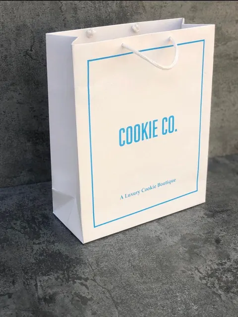 White Cookie Co. paper bag with a blue frame print and rope handles