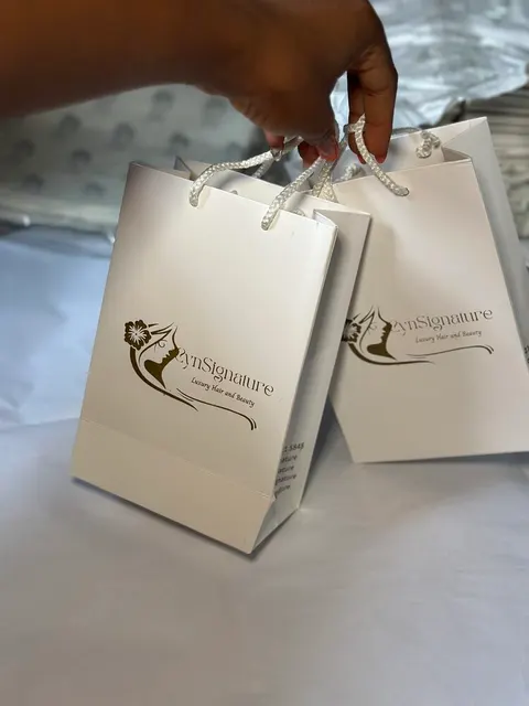 CynSignature cream gift bag with rope handles and foil logo