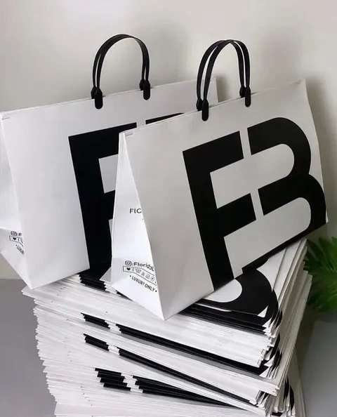 Black and gold Rubycraft38 gift boxes and carrier bags printed by TSH, stacked in the studio